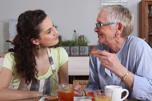 Femme senior prenant un petit déjeuner